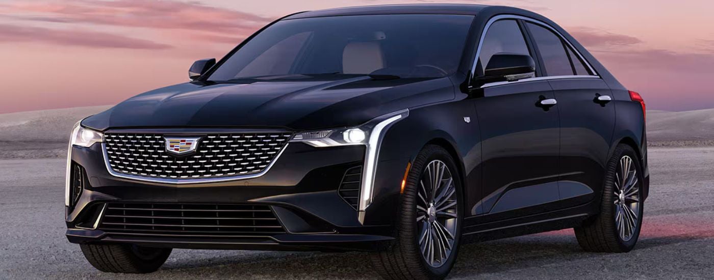 Black 2026 Cadillac CT4 parked in the desert at sunset.