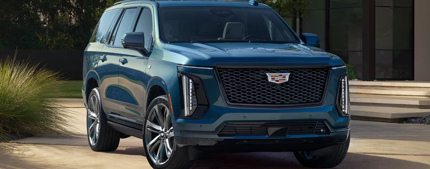Blue 2026 Cadillac Escalade front view parked in a driveway.