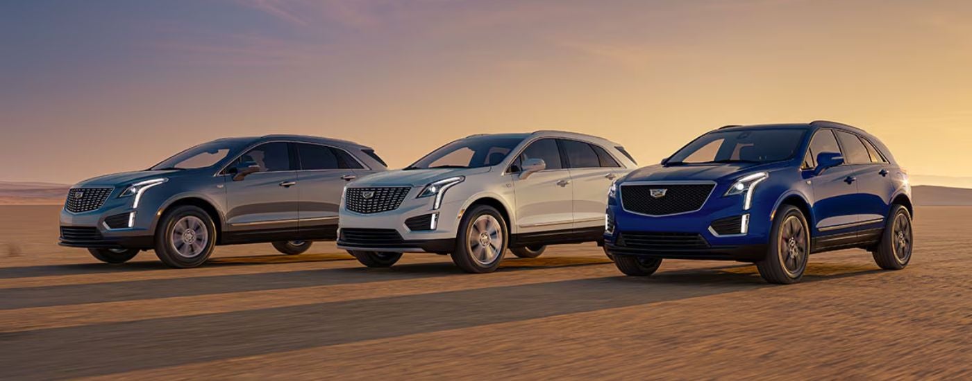 A trio of 2026 Cadillac XT5 in Grey, White, and Blue in the desert.