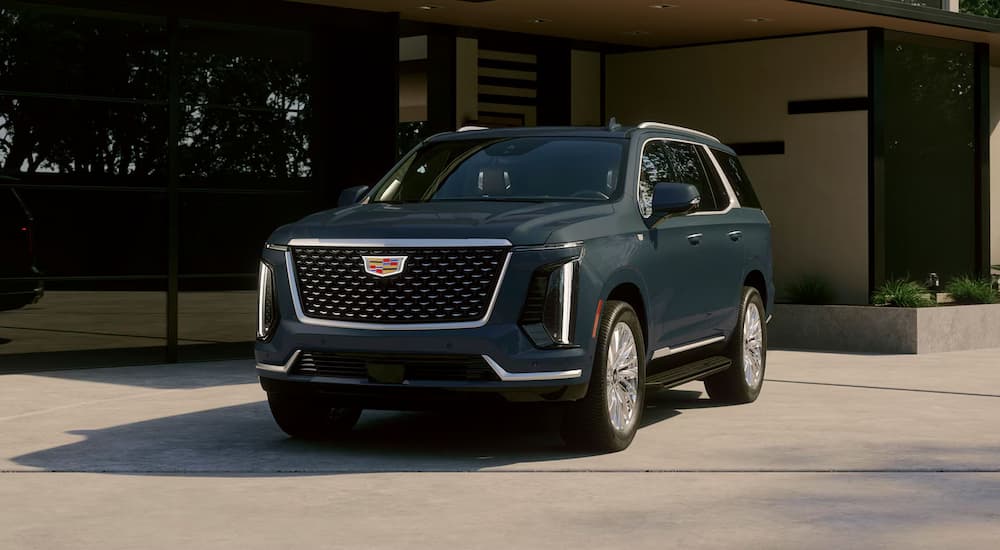 Green 2027 Cadillac Escalade parked in front of a building.