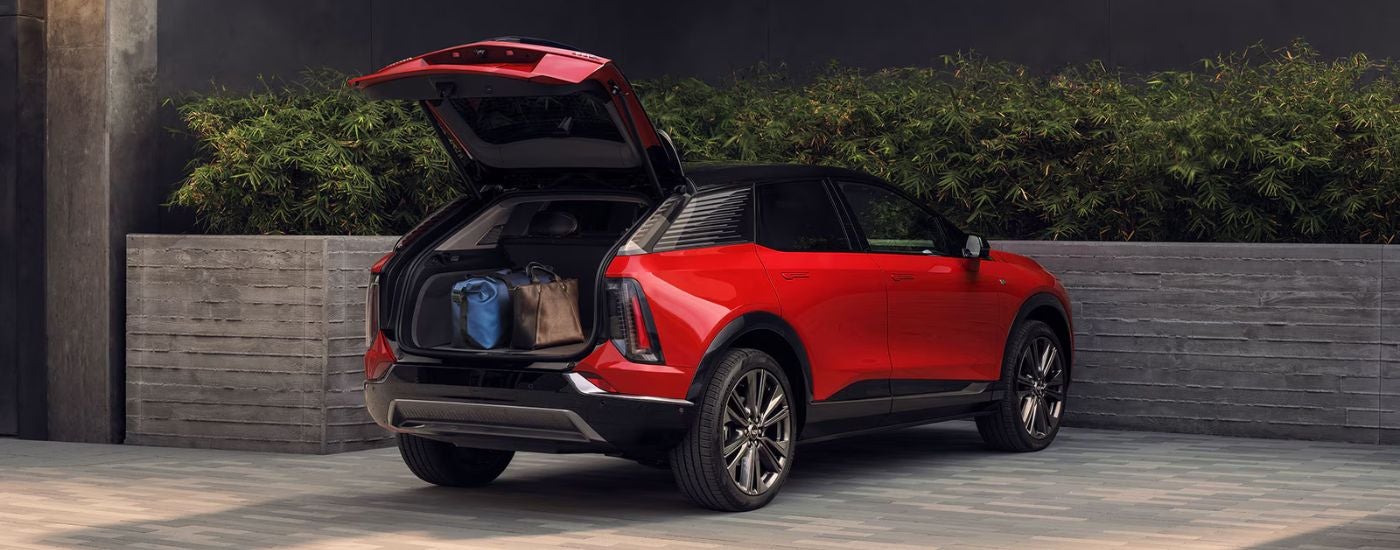 A red 2027 Cadillac OPTIQ with rear gate open. 