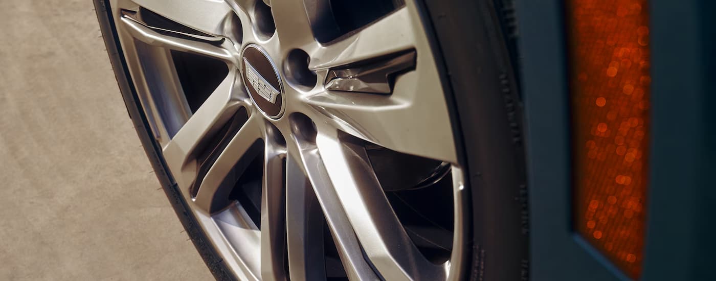 A close up of the tire and rim on a blue 2025 Cadillac Escalade.