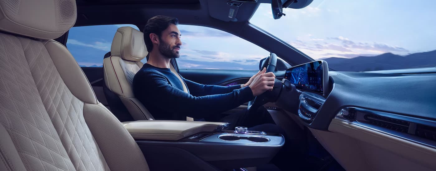 A man is driving in a 2025 Cadillac LYRIQ.