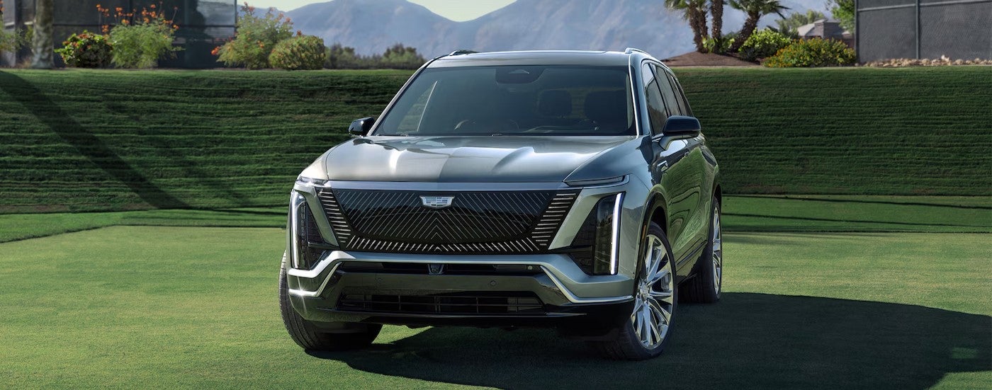 A silver 2026 Cadillac VISTIQ parked on green grass.