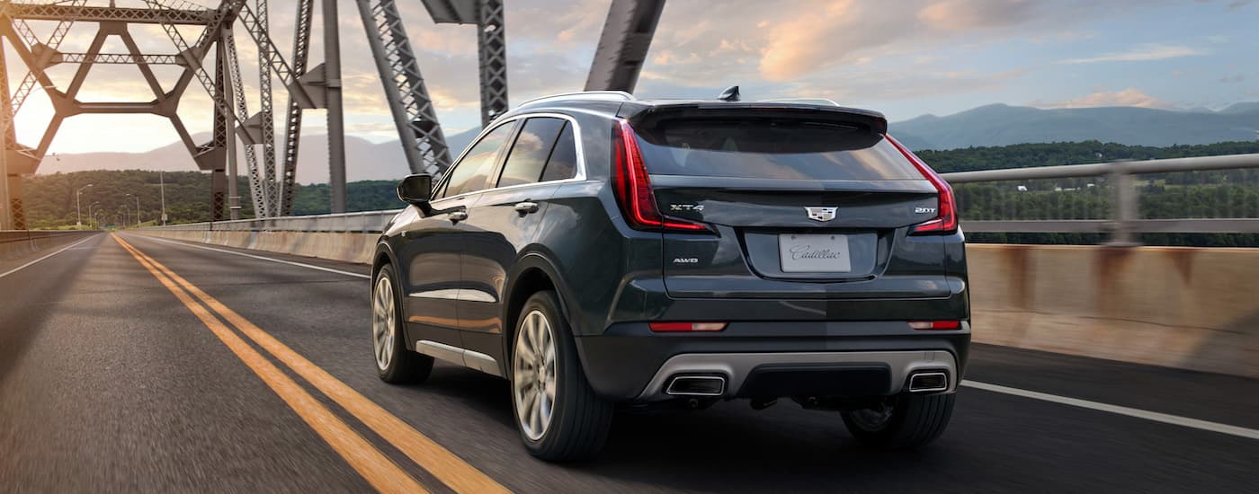 Rear of a blue 2020 Cadillac XT4 driving on a bridge.