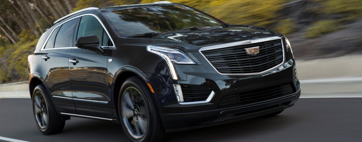Black 2019 Cadillac XT5 Sport driving down an open road.