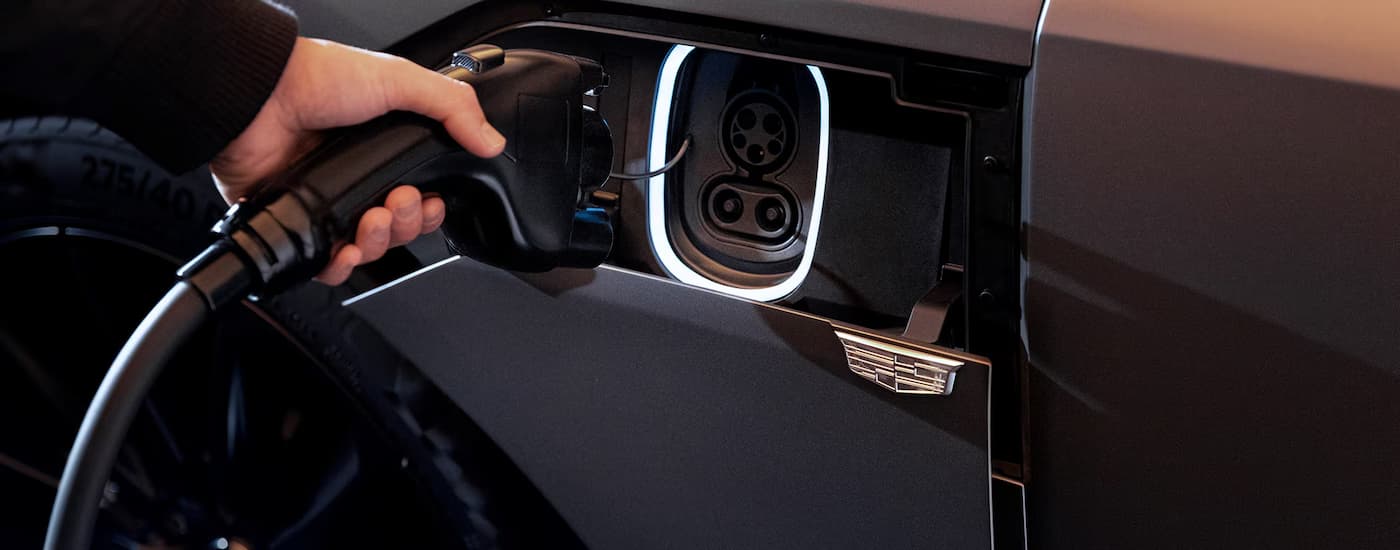 A person plugging in a 2026 Cadillac LYRIQ-V to charge 